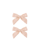 Two blush pink hair bows on a white background