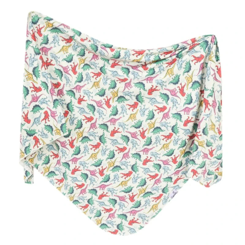 A knit swaddle blanket with a pattern of various dinosaurs from the Jurassic Park era in a multicolor design on a white background.