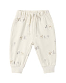 Off-white jogger pants for toddlers, featuring an all-over print of small deer and pine trees in muted gray and beige tones, with an elastic waistband and drawstring.