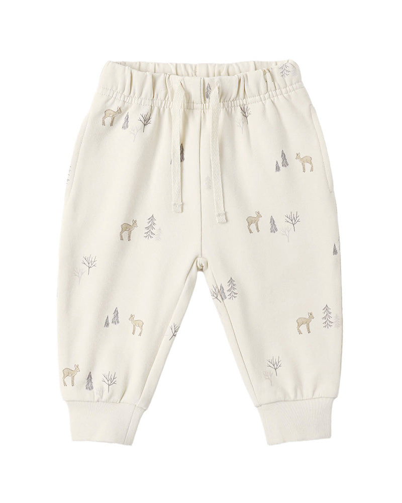 Off-white jogger pants for toddlers, featuring an all-over print of small deer and pine trees in muted gray and beige tones, with an elastic waistband and drawstring.