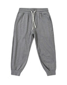 Gray cuffed joggers with a white drawstring and pockets on a white background