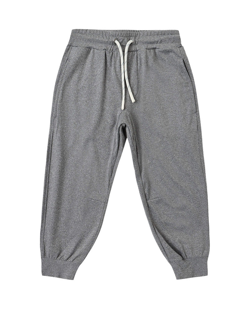 Gray cuffed joggers with a white drawstring and pockets on a white background