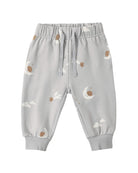 Light gray baby jogger pants with a celestial print of crescent moons, stars, and clouds, featuring an elastic waistband with drawstrings and ribbed ankle cuffs.