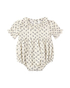 Baby romper with floral pattern and a ruffled collar and sleeves on a white background