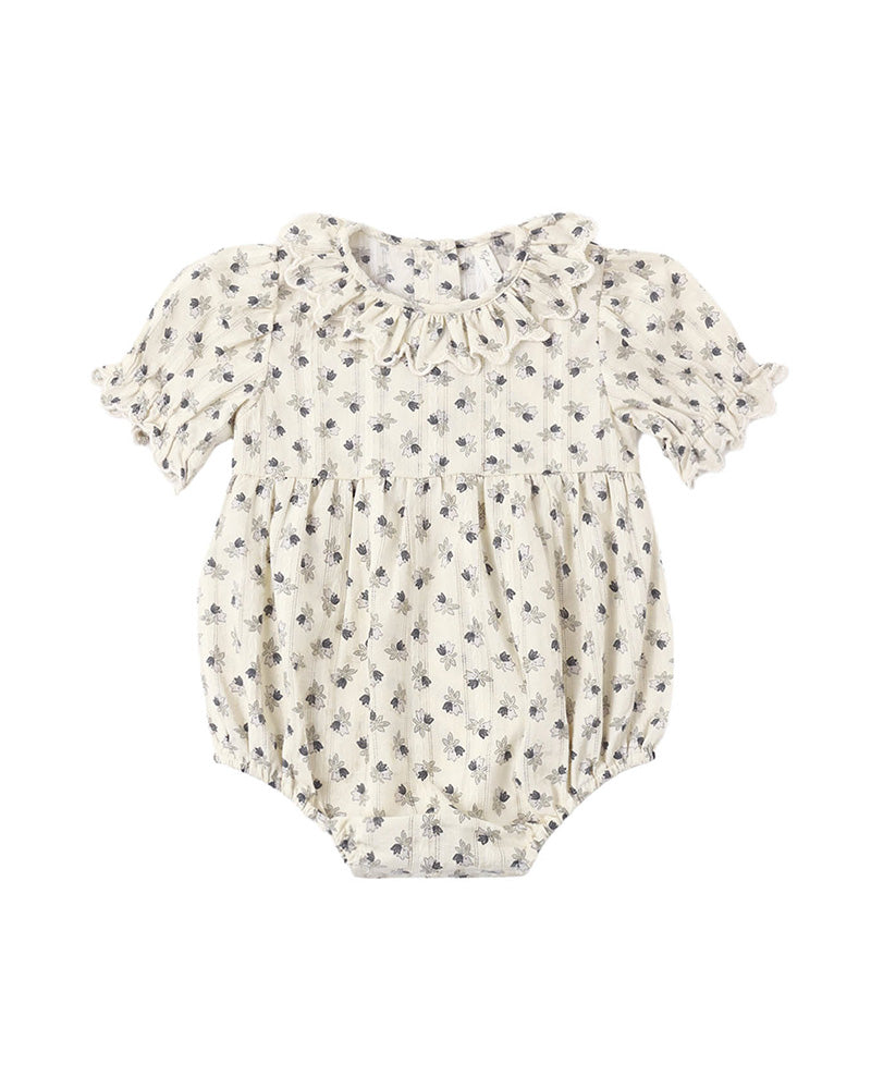 Baby romper with floral pattern and a ruffled collar and sleeves on a white background