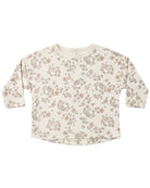 Floral patterned shirt with button shoulder on a plain background