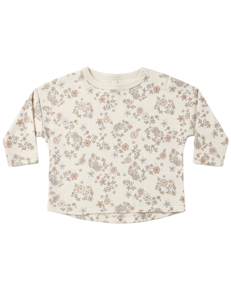 Floral patterned shirt with button shoulder on a plain background
