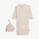 Baby gown and hat set with pink trim and a small floral pattern on a white background