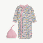 Baby onesie and hat set with pink ruffle trim and a floral pattern