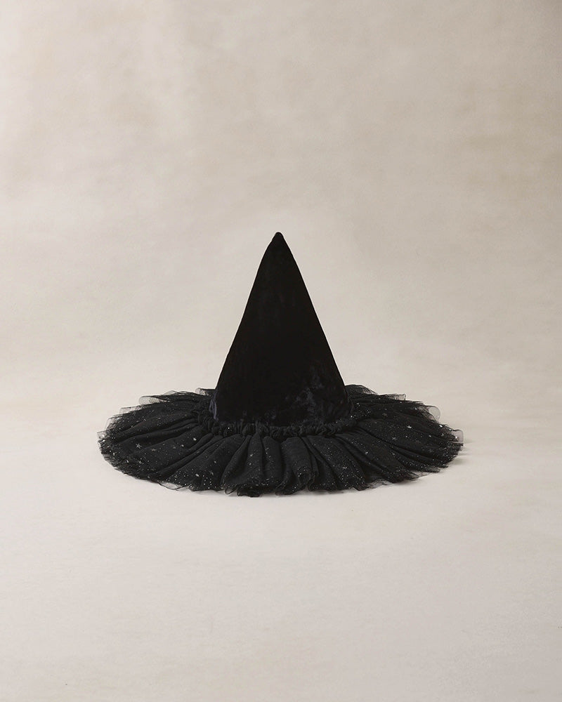 Black witch hat with a fluffy tulle base and a sparkly detail on a beige background