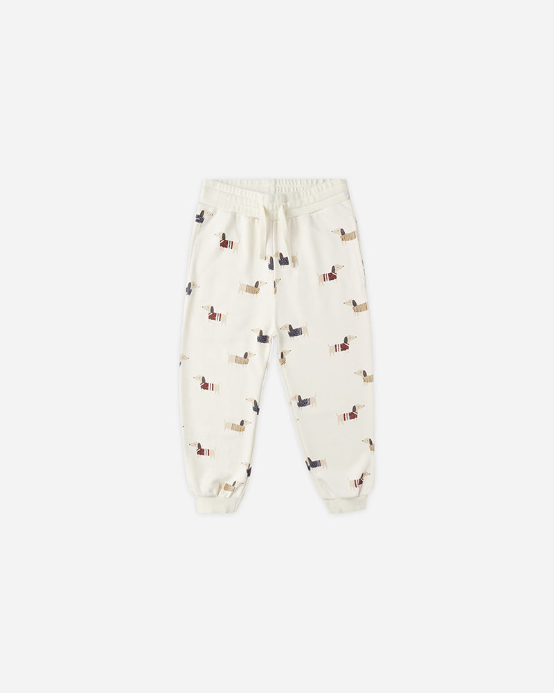 Cream-colored jogger pants with small dog pattern on a white background