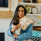 woman holding infant with cow print burp cloth over shoulder