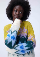 Person wearing a colorful sweater with abstract patterns on a white background